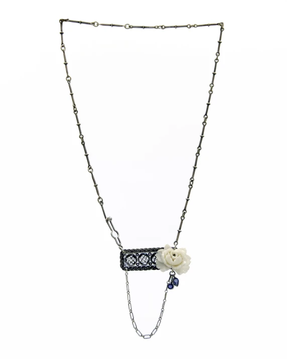 a flower and chain necklace hangs from a silver necklace