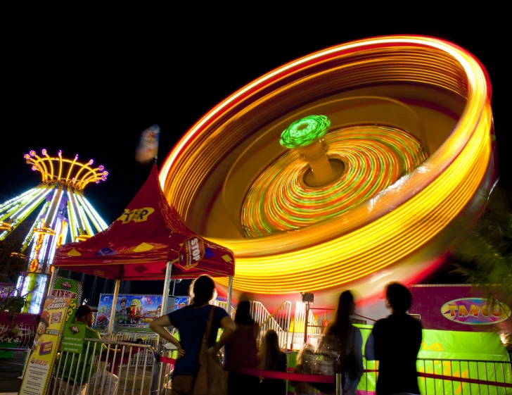 a group of people standing in front of a carnival