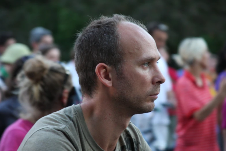 a man wearing a gray shirt and many people