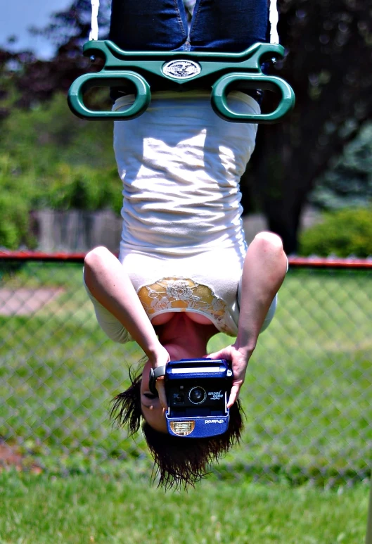 a woman doing a handstand in front of a fence