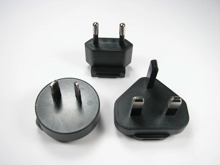 three black plugs with wires are shown