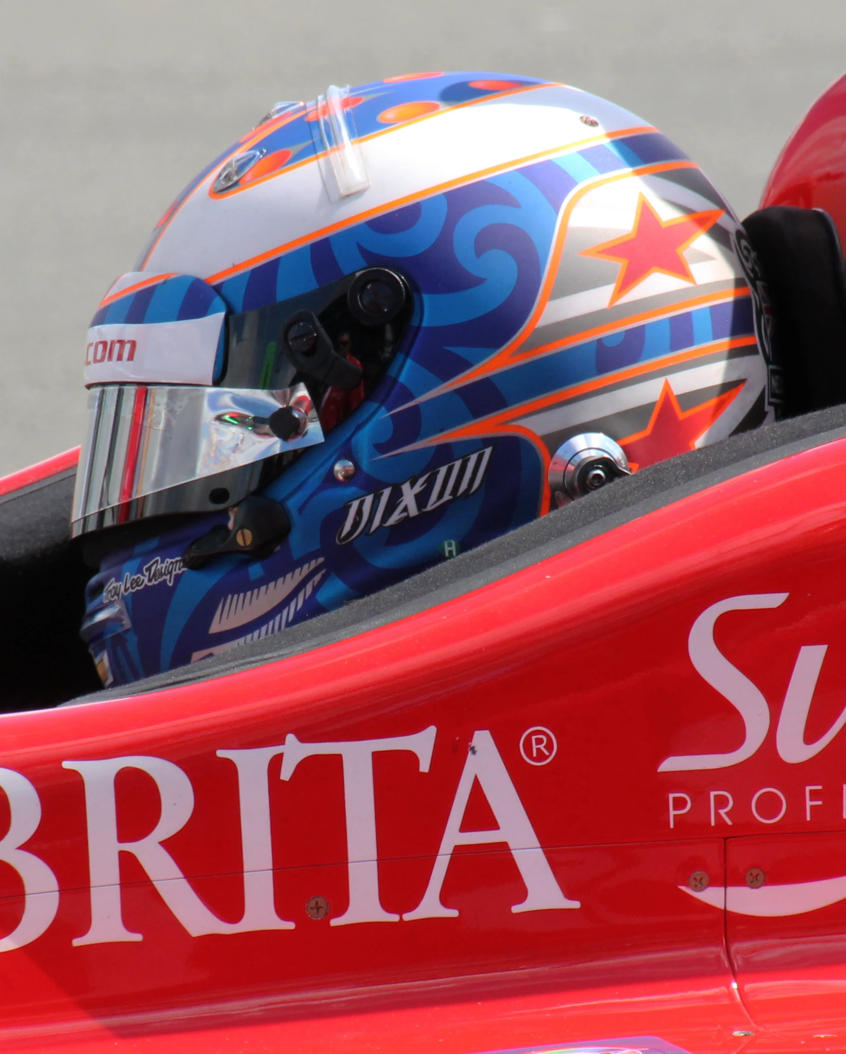 a man wearing a racing helmet drives his car