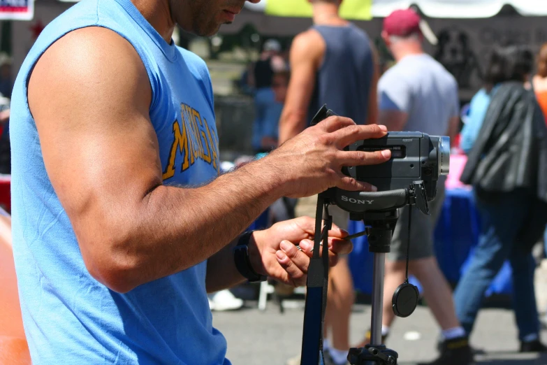 a person with blue vest working on the electronic device