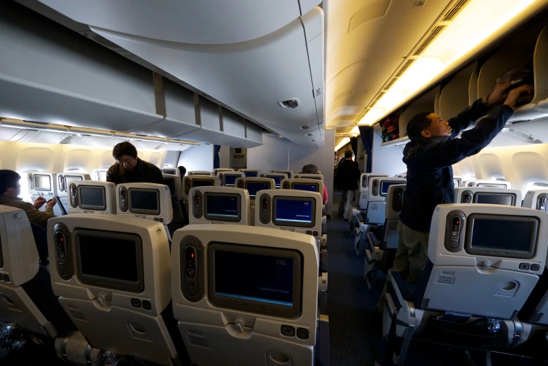 a man is pointing out the back window of an airplane