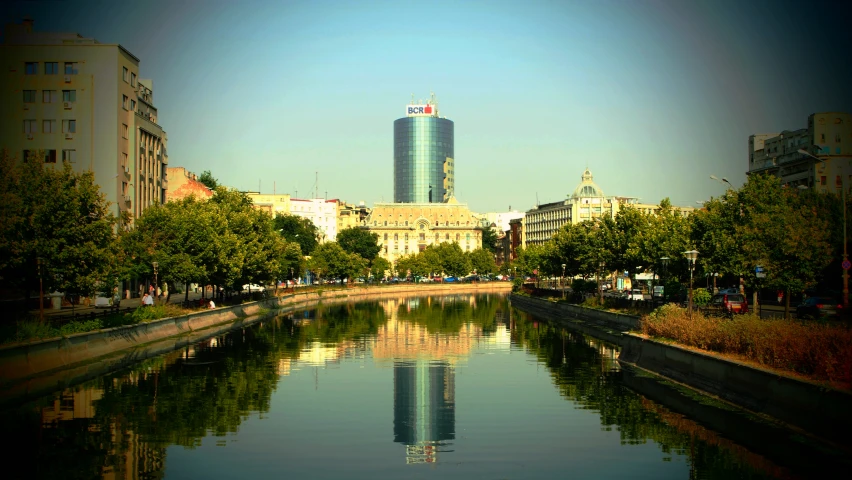 a river in a city is shown as the sun shines in the background