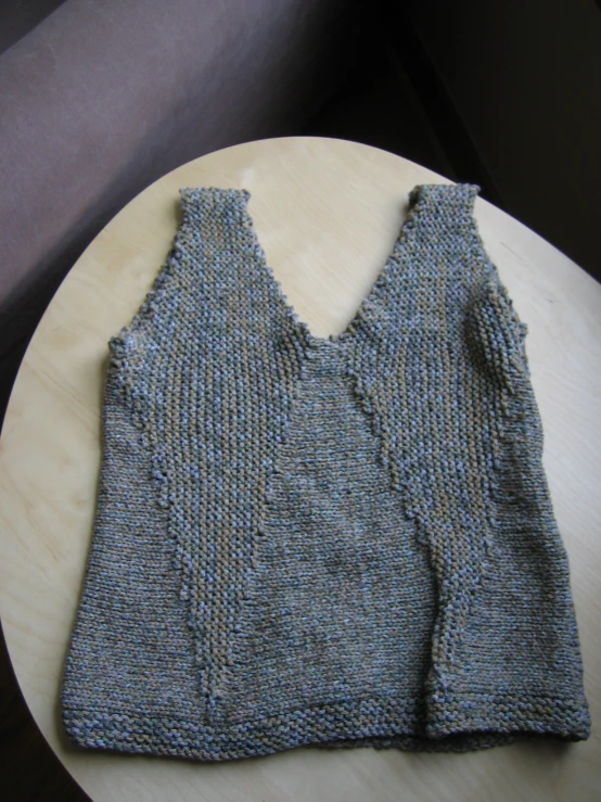 two pieces of gray knitted material sitting on a table