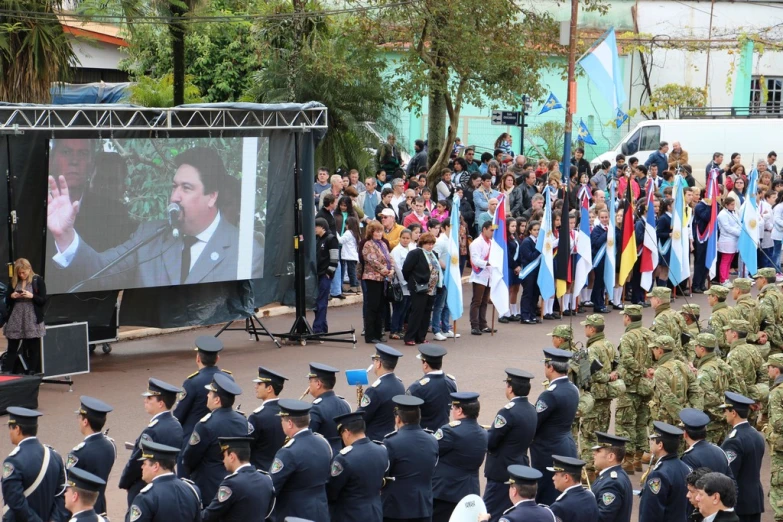 several military officers stand near a podium with people watching them