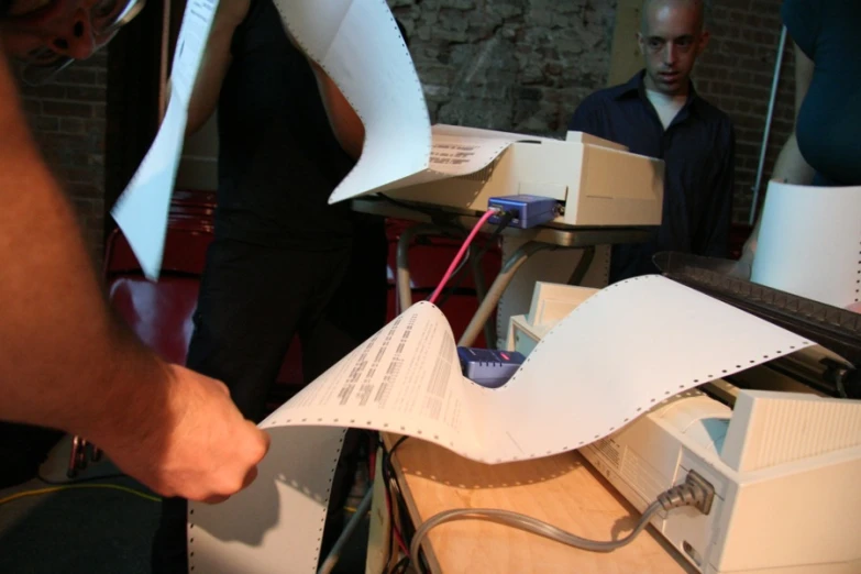 a pair of workers at an electronics shop are  paper