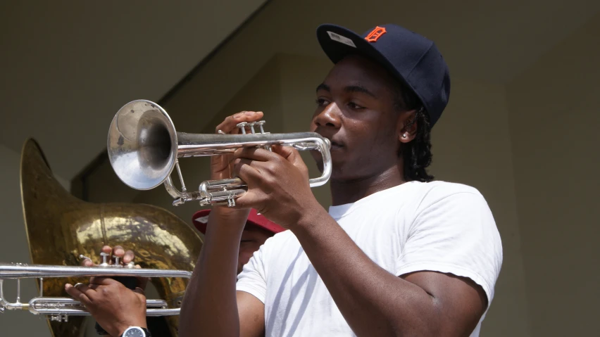 a man playing a trombone with a blue cap