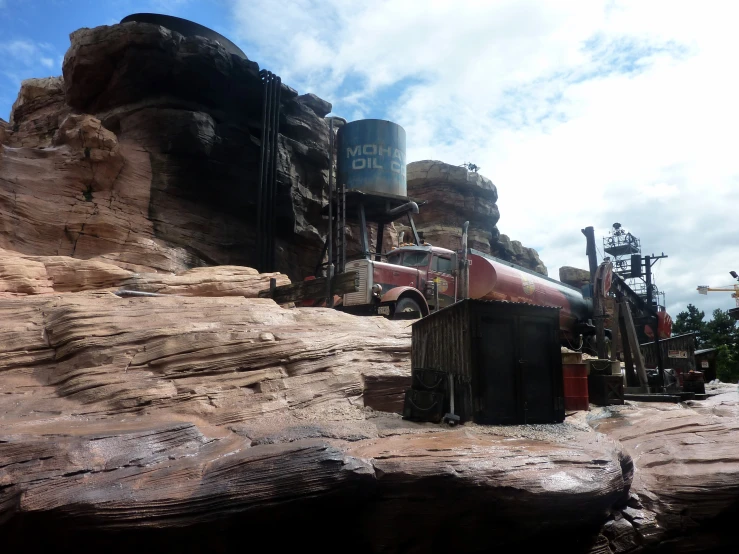 a train station with lots of equipment near a mountain