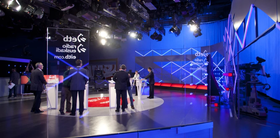 several people at a television set having their picture taken