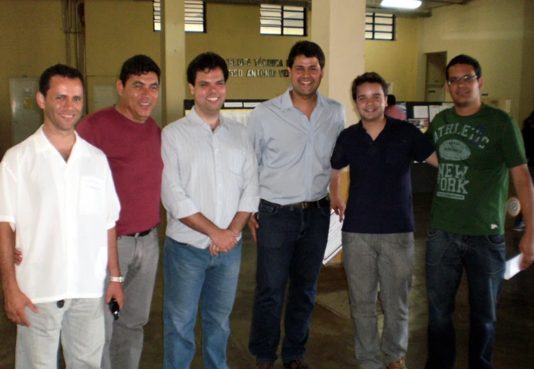 a group of men standing next to each other smiling