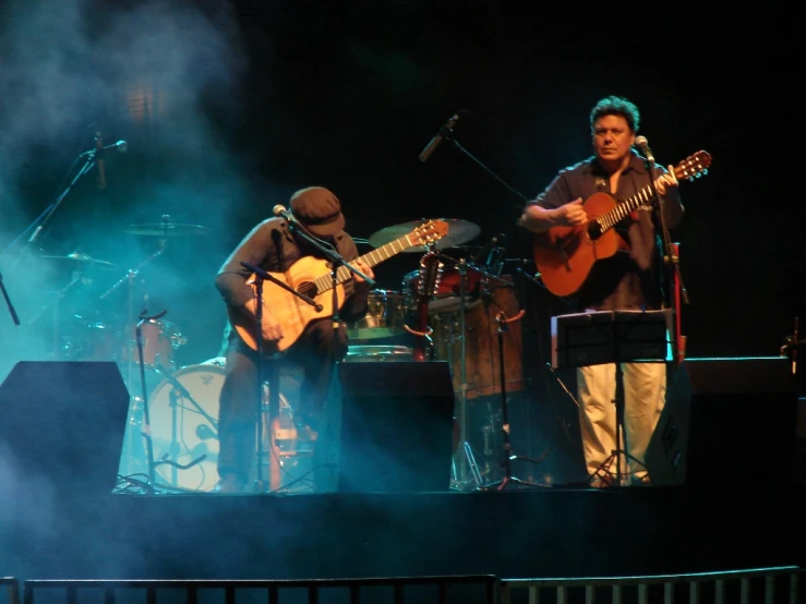 a couple of people are playing guitars on stage