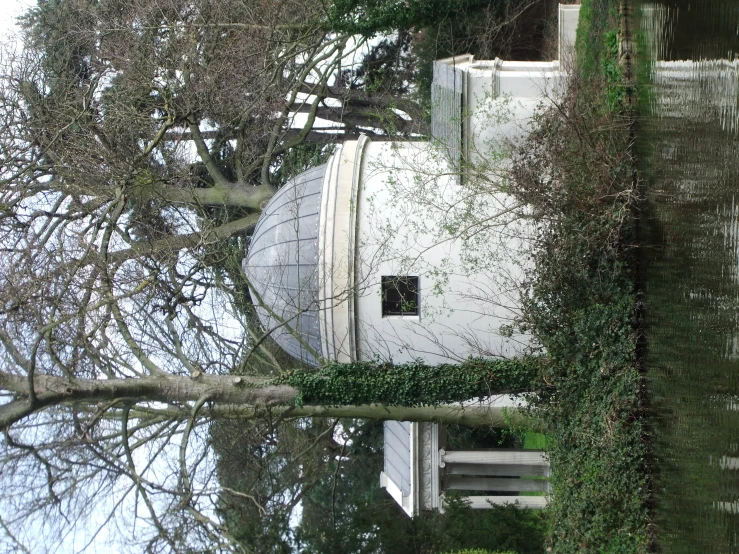 an old white building with a dome by the water