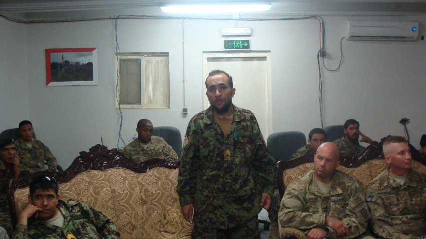 a man with a beard standing in a group of military personnel