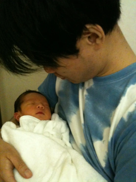 a young man holding a baby on his lap