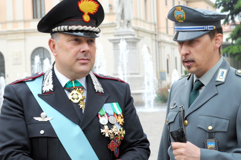 two military men stand in formation in a courtyard