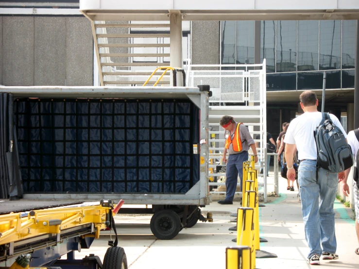 men on construction platforms loading a large crate