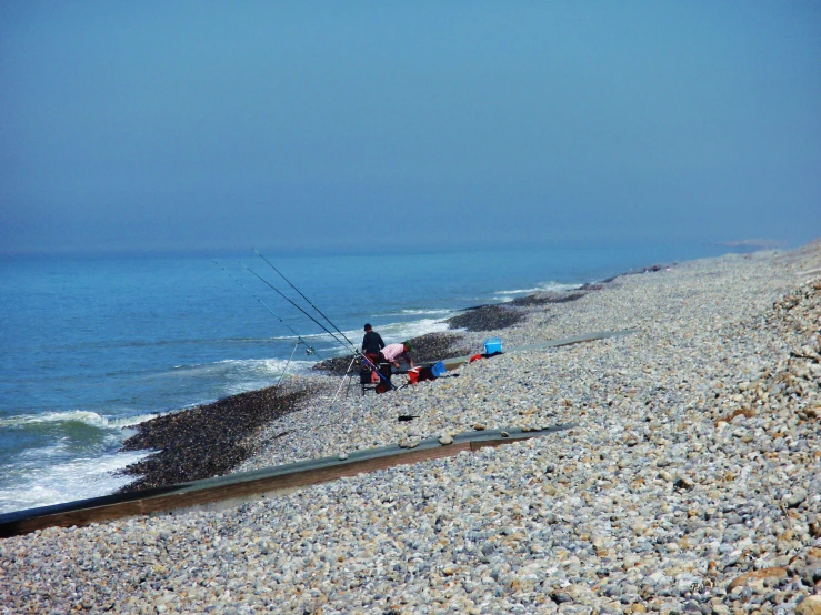 a couple of people on a beach with fishing