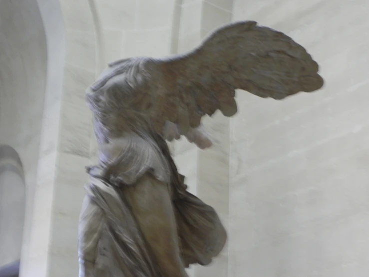 an angel is flying high above a statue