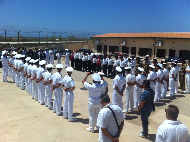 navy officers in dress uniforms standing on a ramp