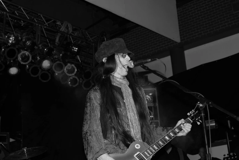 a woman in a hat plays a guitar