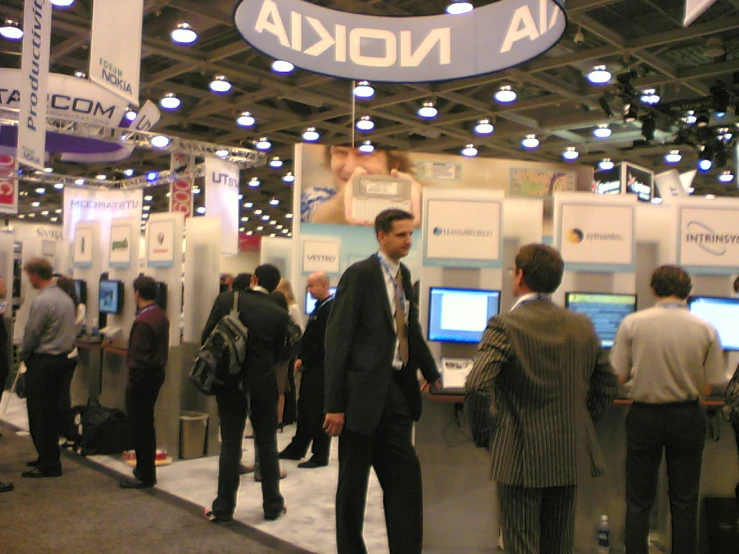 some people standing around a trade show booth