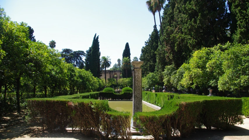 the tall clock is displayed near the hedges