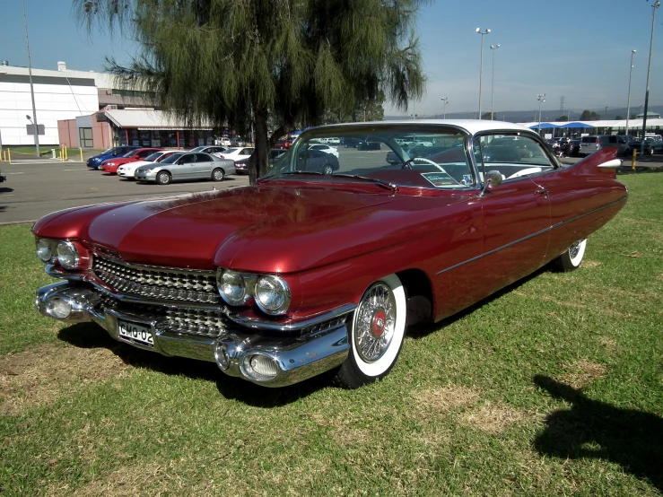 the large red car is parked in the grass