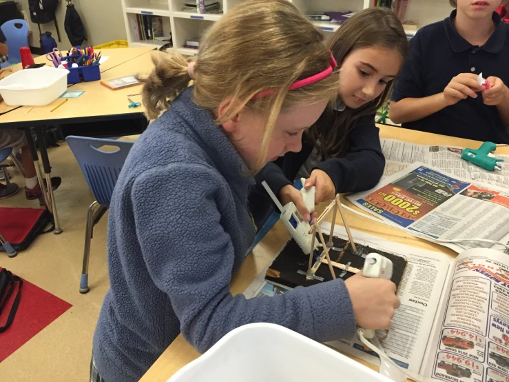 three children using wires to make a project