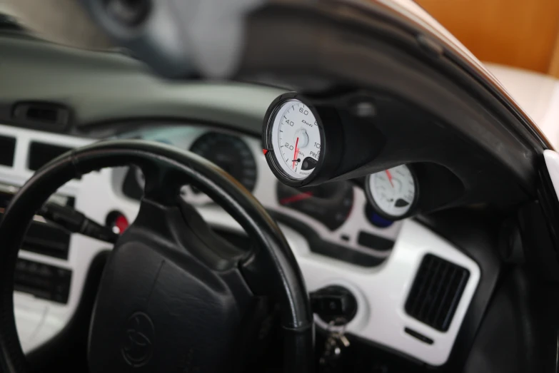 a car with a clock mounted to the dashboard and a steering wheel
