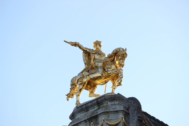 the statue of a person sitting on top of a stone statue