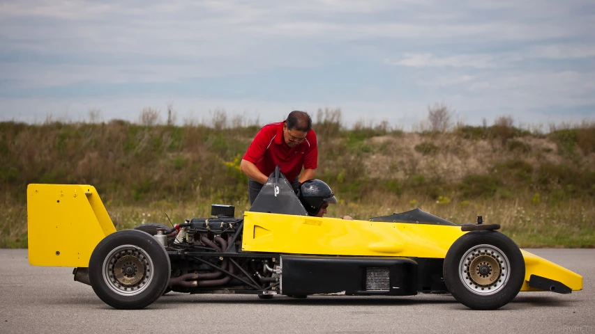 a man working on a race car in the street