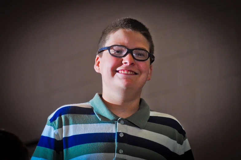 a boy is dressed in glasses and smiling