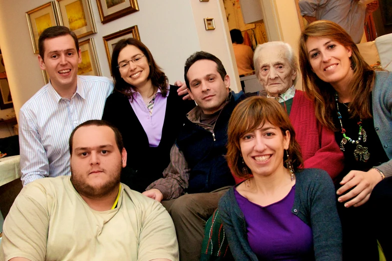 several people posing for a po on a couch