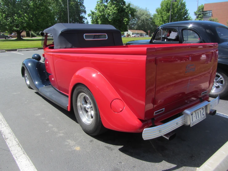 a large red classic car parked on the side of the road