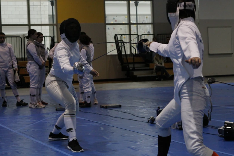 some people in fencing gear standing on a court