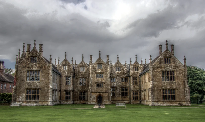 a huge, historic building with windows and lots of green grass