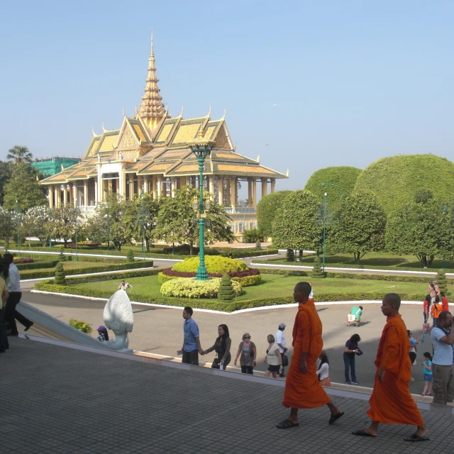 three monks walk through the courtyard to visit the pagoda