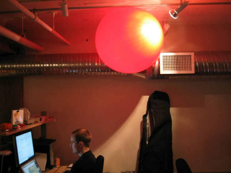 there are people in a computer lab with big red balloons