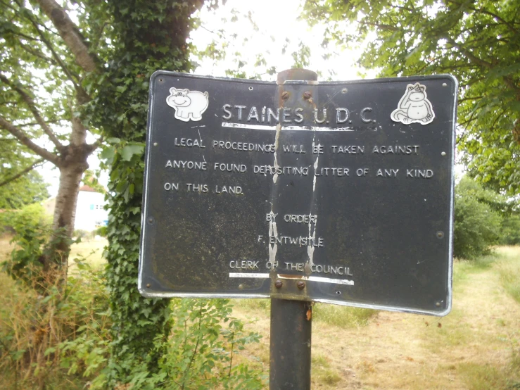 a sign posted on top of a post in the woods