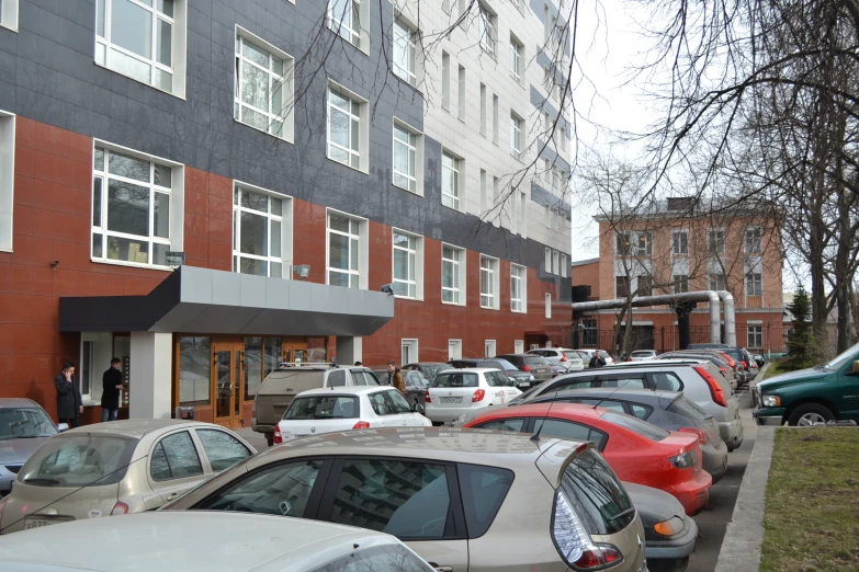 several cars parked along a busy city sidewalk