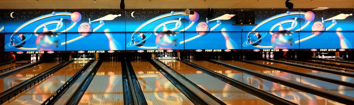 bowling alley wall with bowling balls, artwork and signs
