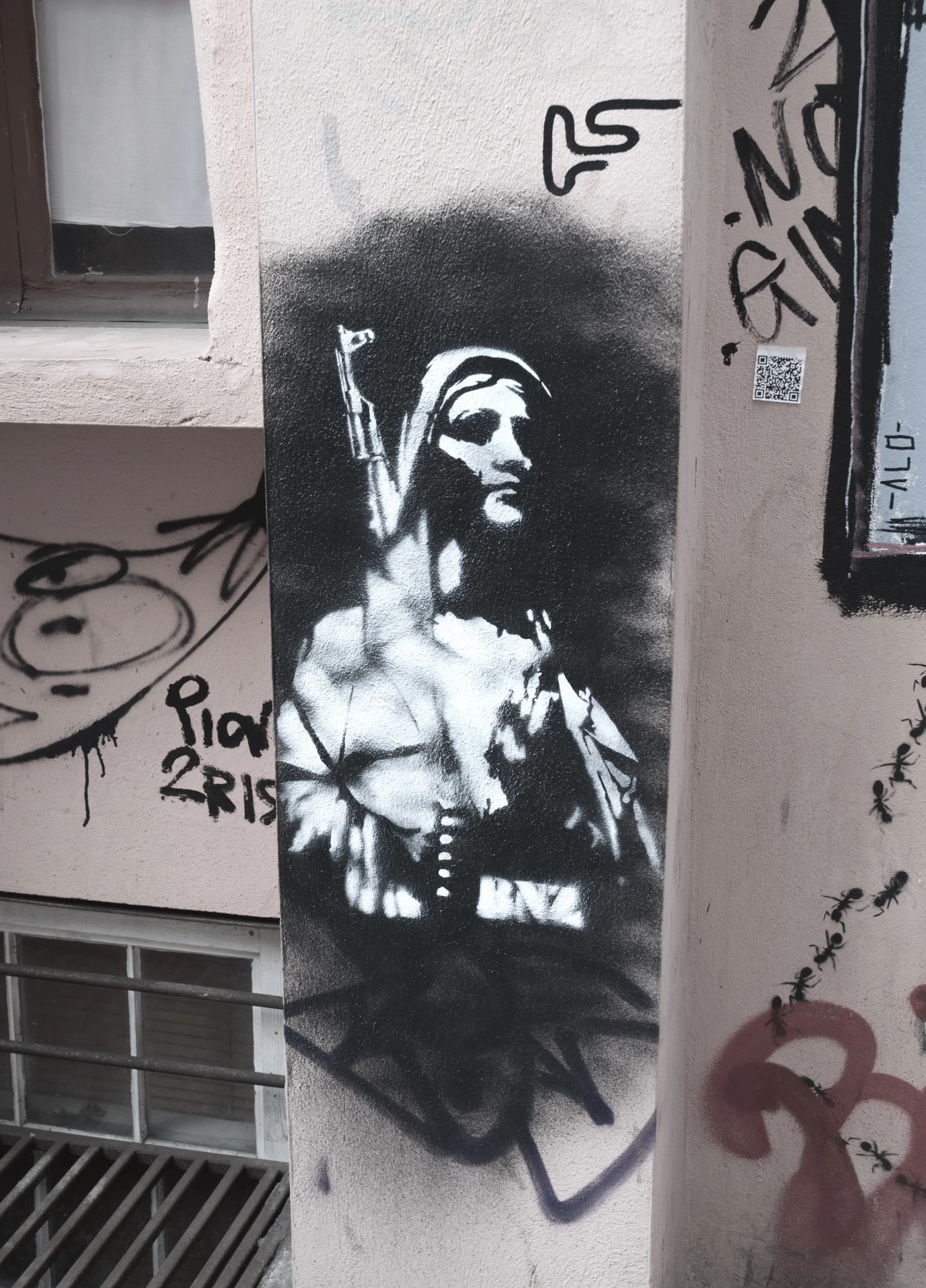 the graffitti on the wall shows a man holding a gun