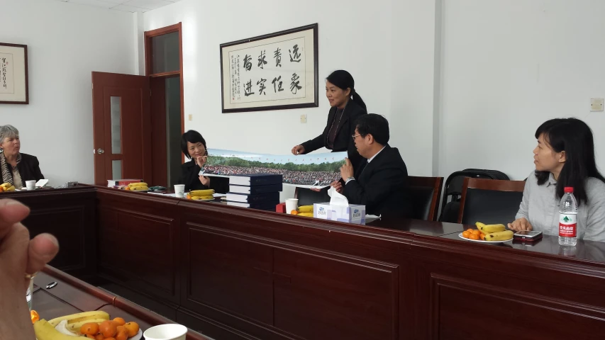 four women in formal clothing sitting at an empty meeting room