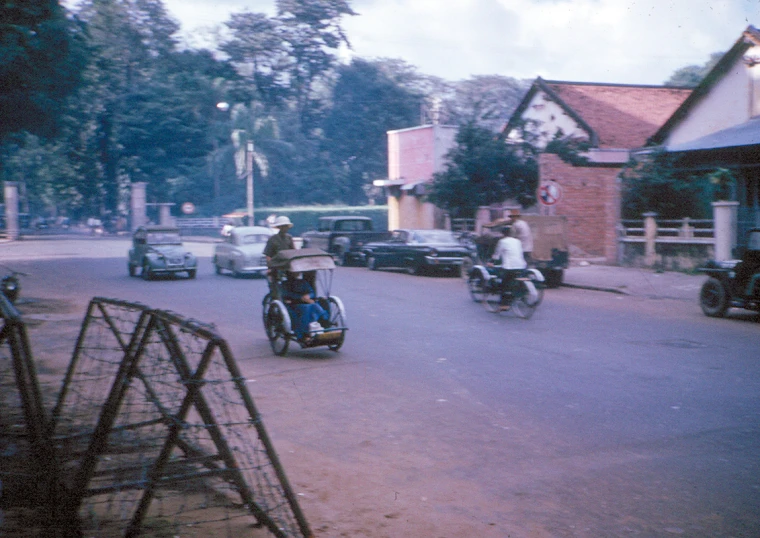 motorcyclists ride down the road on a small town street