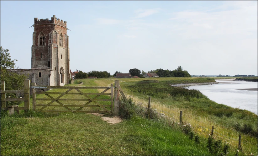 an old tower stands near a river