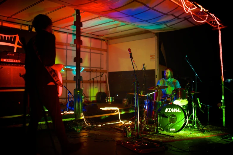 a person playing guitar in a garage while others watch