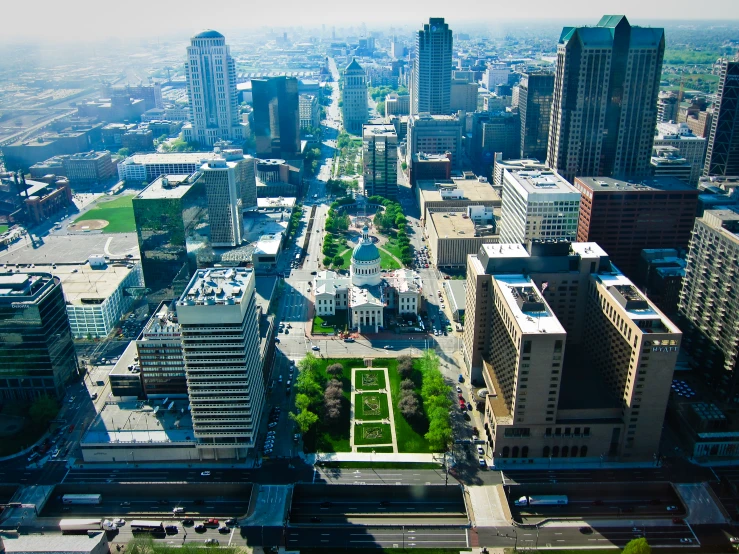 an aerial view of a city with tall buildings and many green spaces