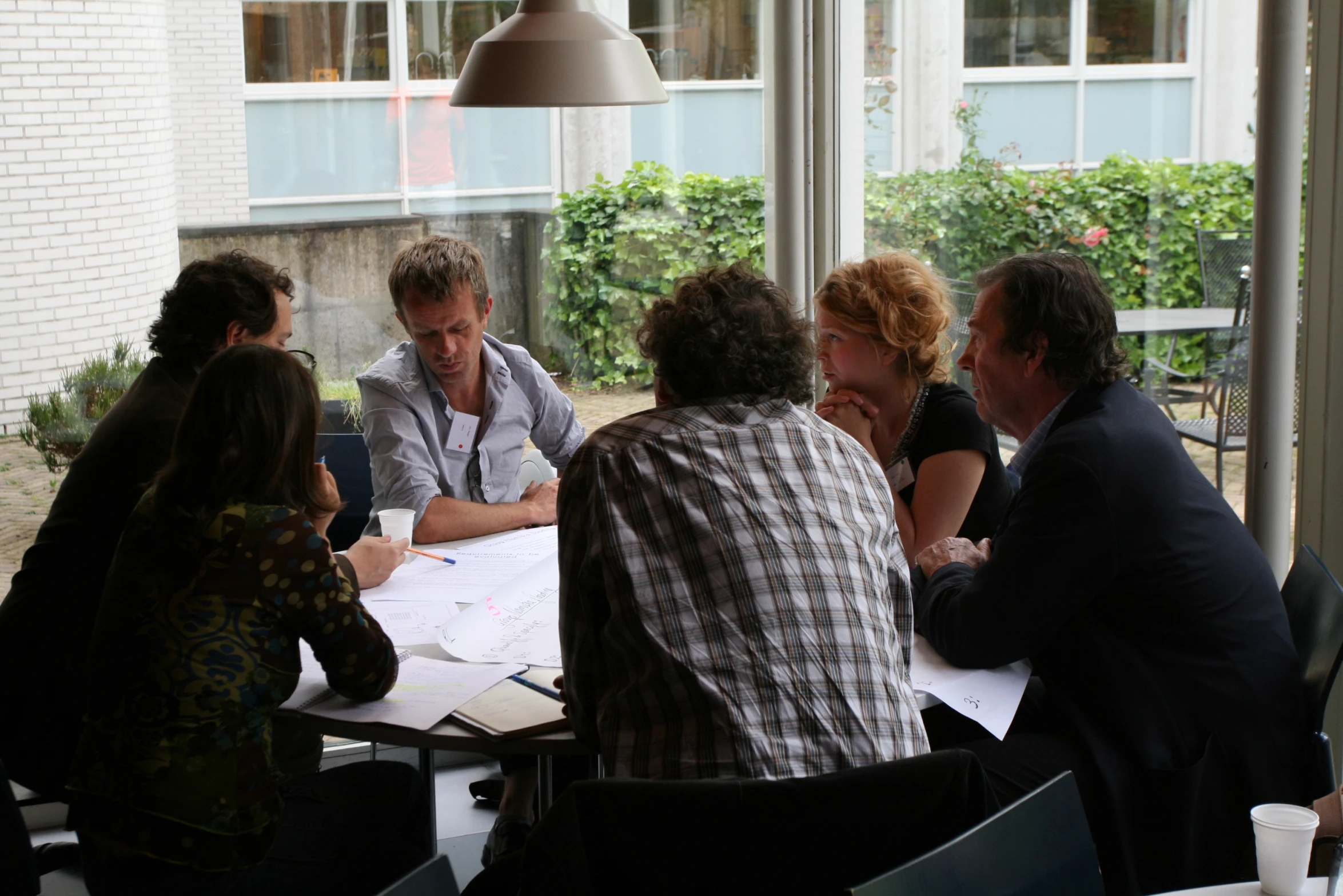 six people sitting around a table having a conversation